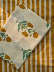 White fabric with green and orange leaf patterns on a striped background