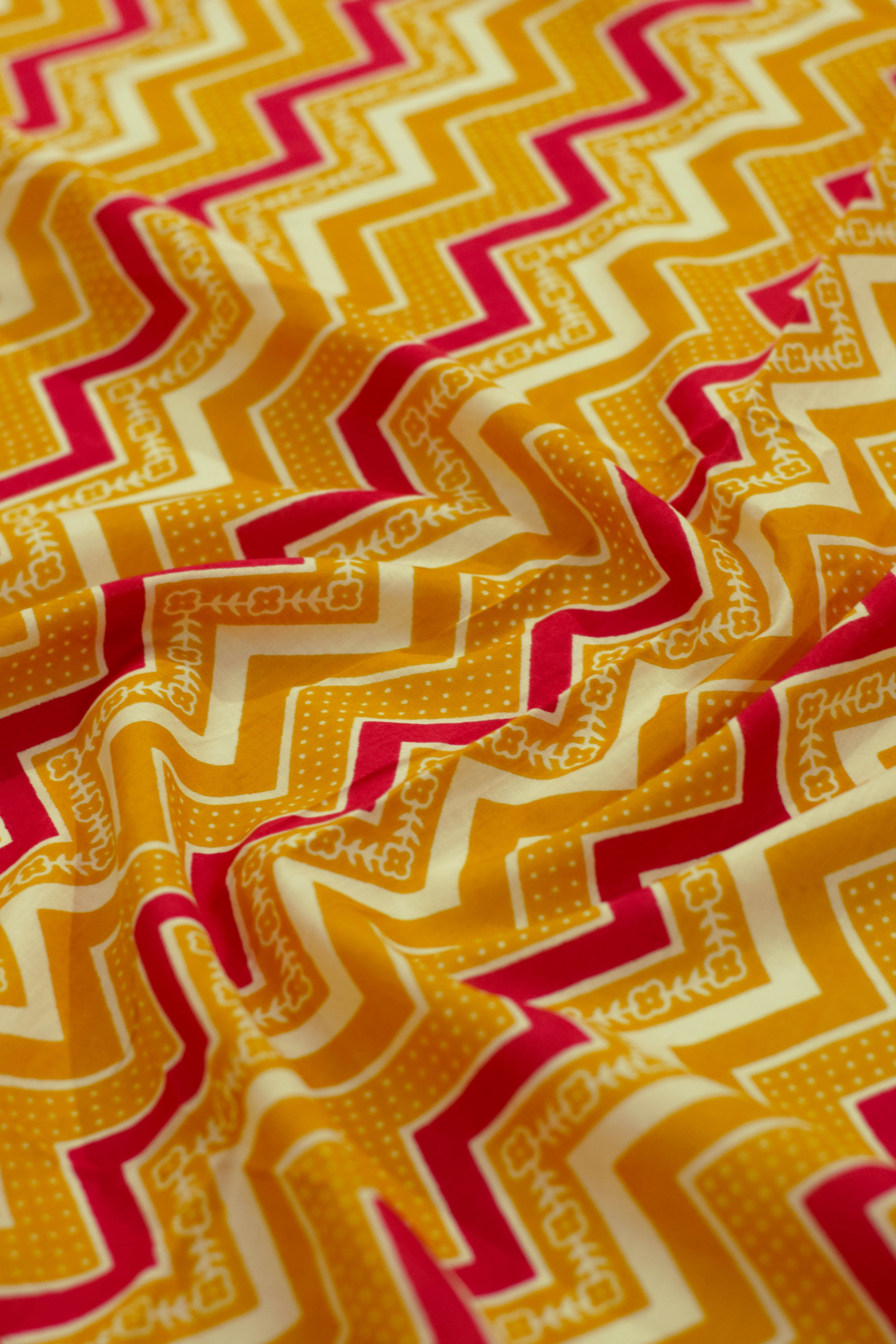 Close-up of zigzag pattern fabric in orange, red, and white.