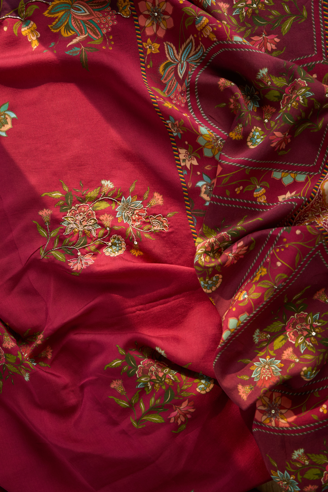 Close-up of a maroon fabric with intricate floral embroidery