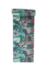 A swatch of fabric featuring a tropical botanical pattern with lush greens, muted reds, and teal on a grey background.