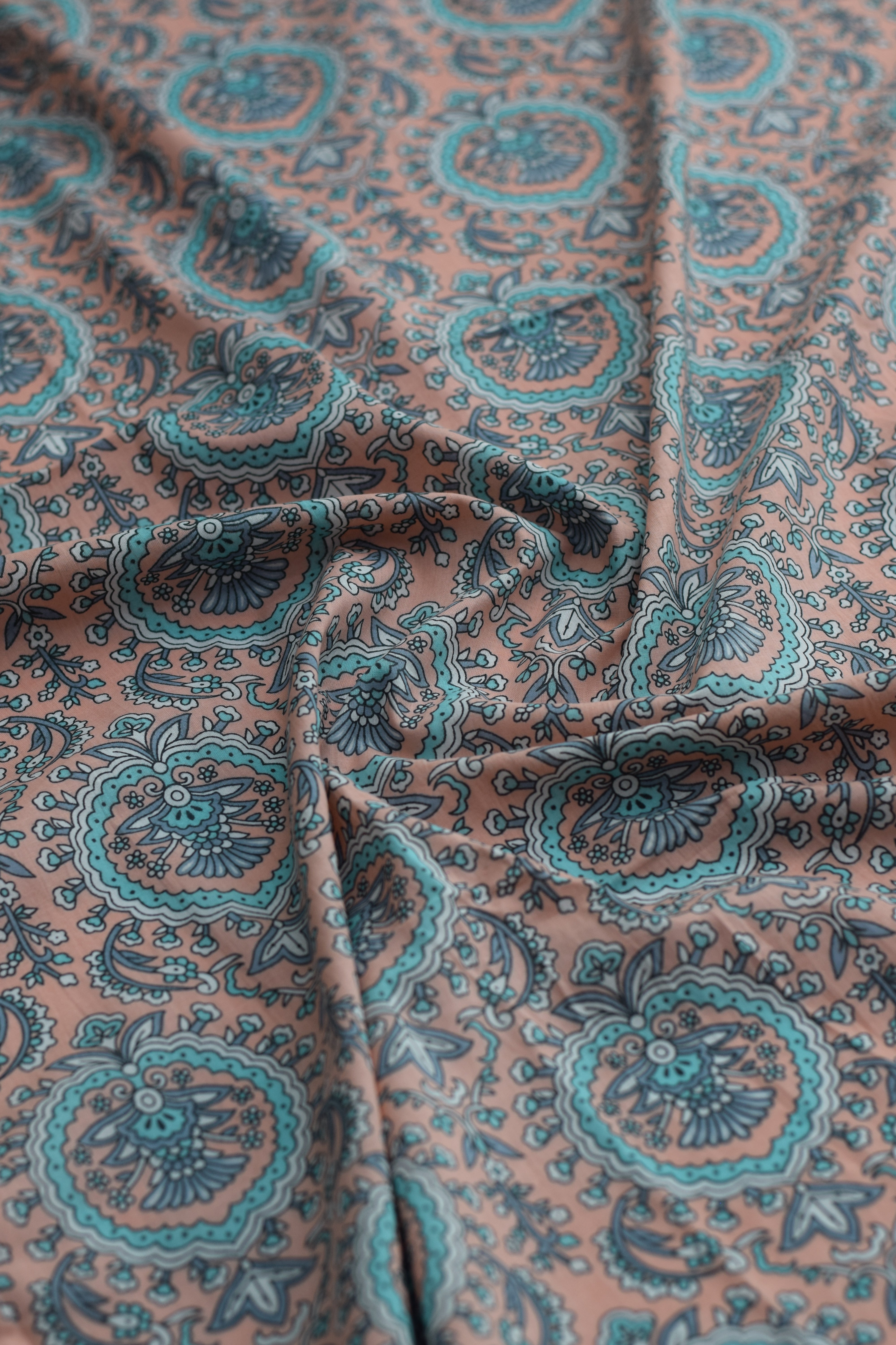 Close-up of paisley-patterned fabric in brown and teal.
