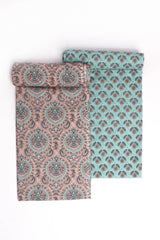 Two pieces of fabric, one with a turquoise base and floral motifs, and the other with a peach Mughal-inspired jaal design.