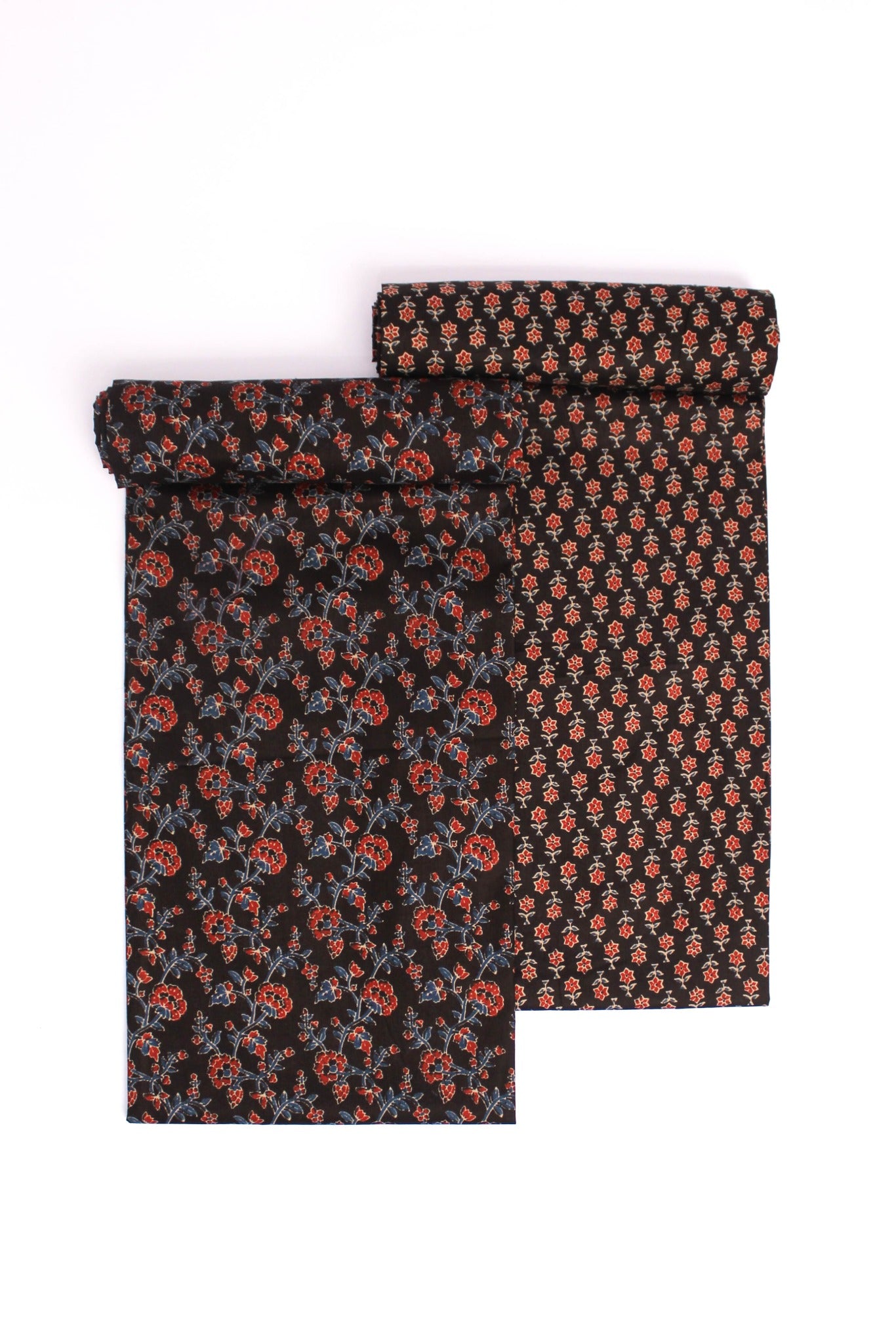 A two-piece suit with one piece displaying a tiny rust and cream floral pattern on a black background and the other piece showing a deeper, more intricate floral design.
