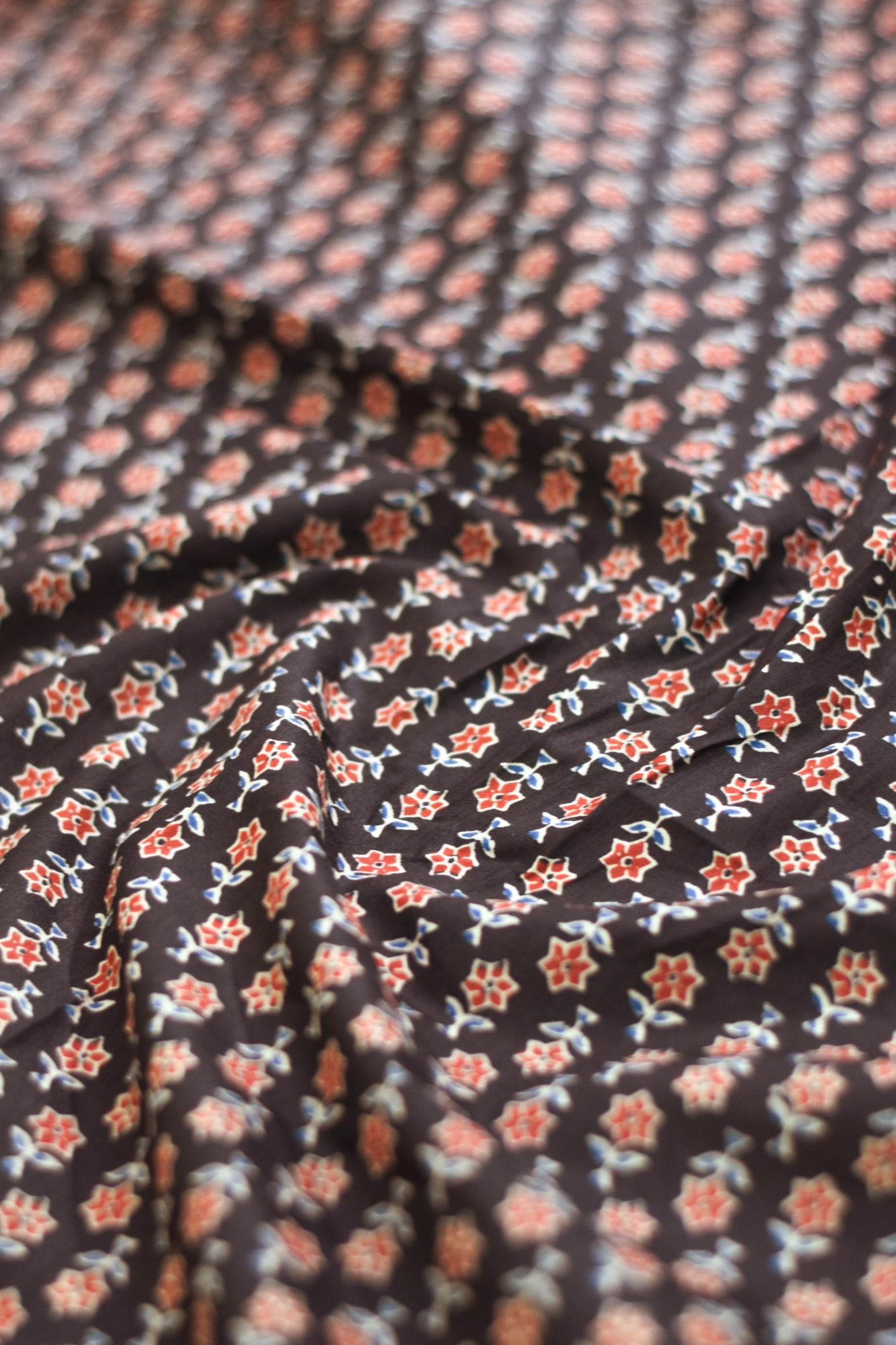 Close-up of floral patterned fabric in black, red, and white.