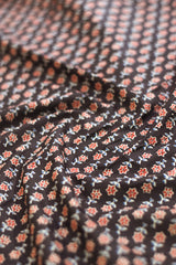 Close-up of floral patterned fabric in black, red, and white.